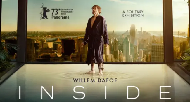 Film poster for "Inside" features WIllem Dafoe standing in an apartment overlooking city skyscrapers. 