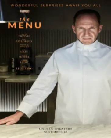 Film poster for "The Menu" displays Ralph fiennes in chef's overalls looking menacing. 