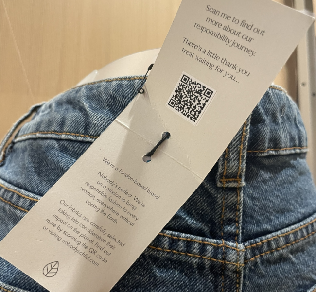 Um passaporte de produto digital digitalizado anexado a um par de jeans. 